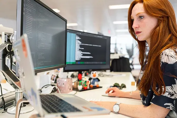 A woman in an office researching knowledge management on her computer